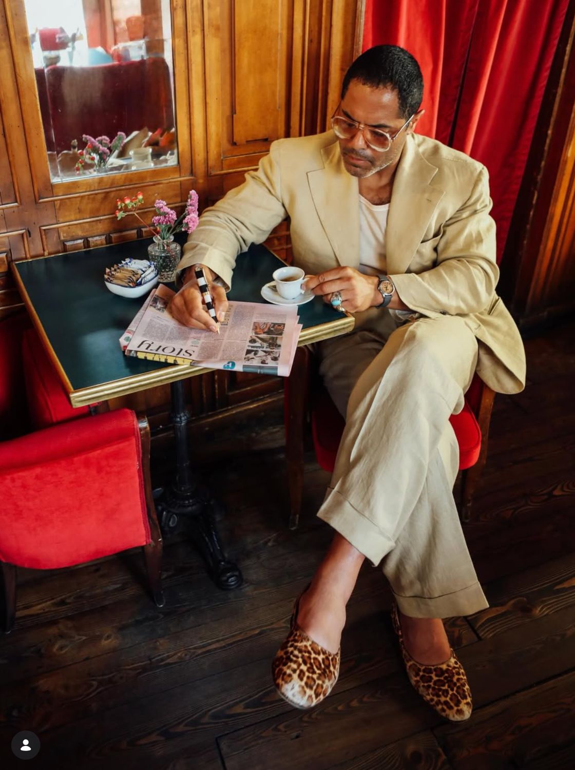 A friend at the table in a cream suit