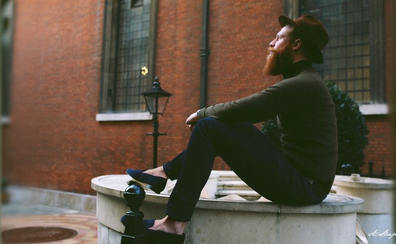 Our first campaign: a man in a fedora and velvet slippers, sitting on a stone fountain