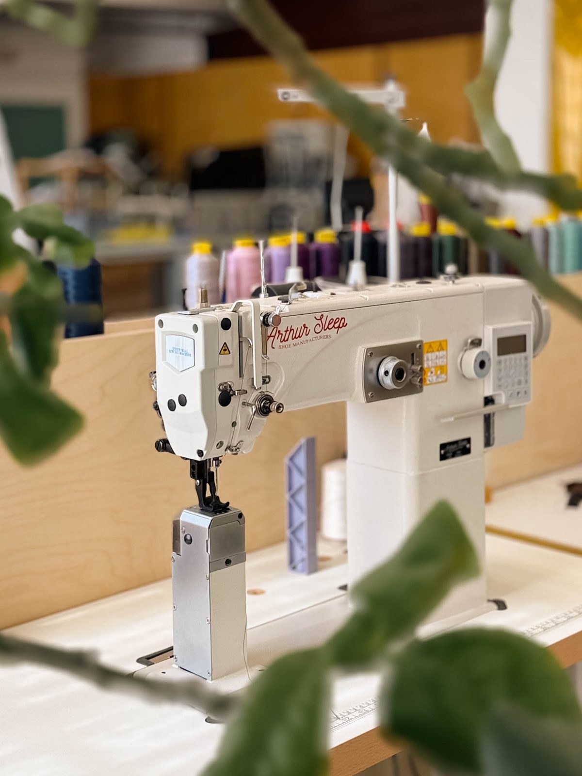 A sewing machine at the factory, thread along the window